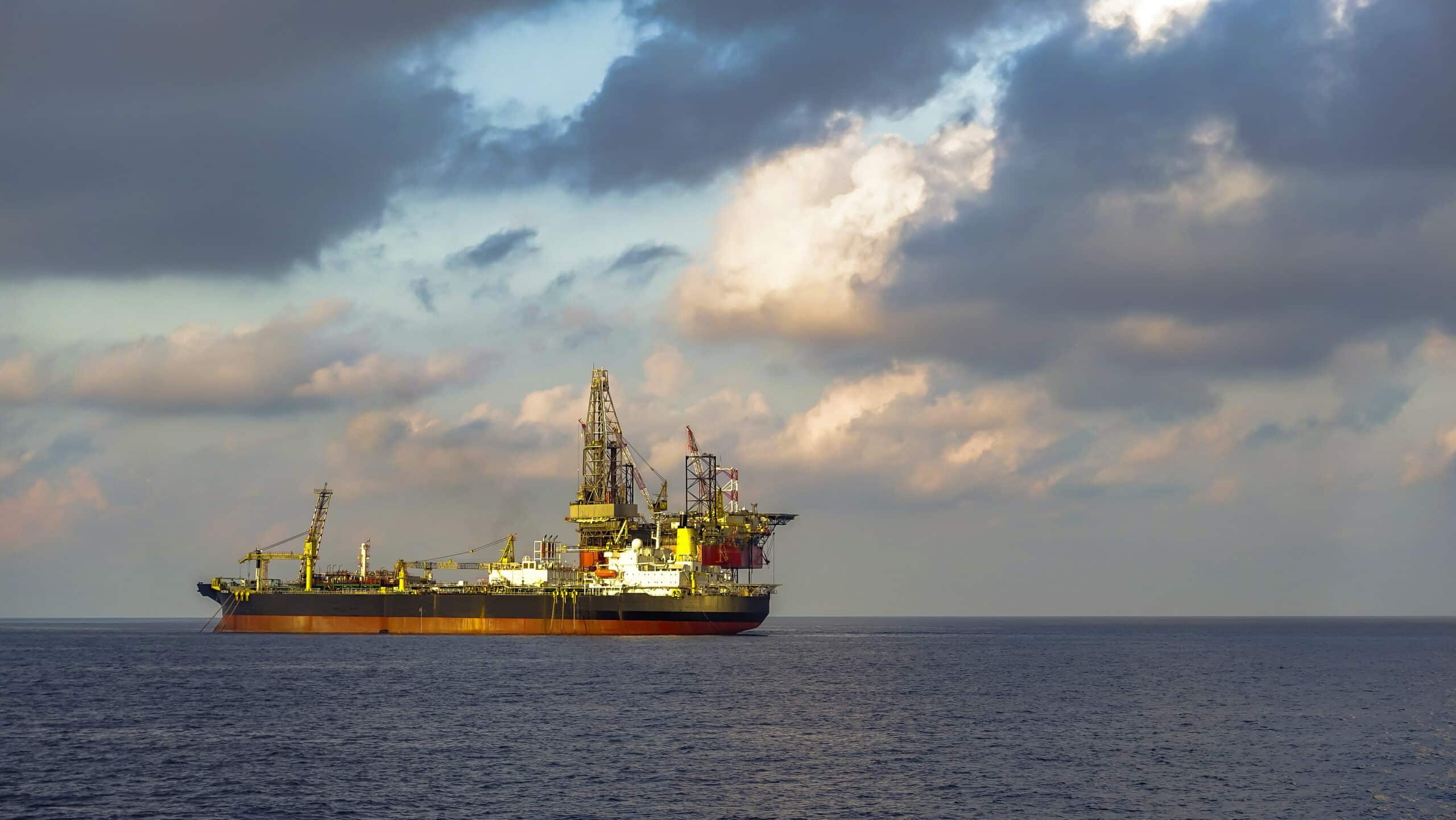 PSO and drilling rig in offshore oil field with beautiful sky.